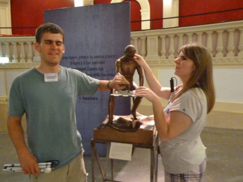 Eine junge Frau ertastet eine Skulptur