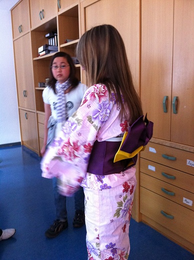 Eine Frau im rosa Kimono, mit einer anderen jungen Frau.