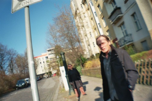 Zwei Passanten an einer Bushaltestelle