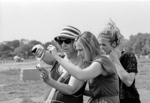Zwei Studentinnen assistieren einer blinden Fotografin.