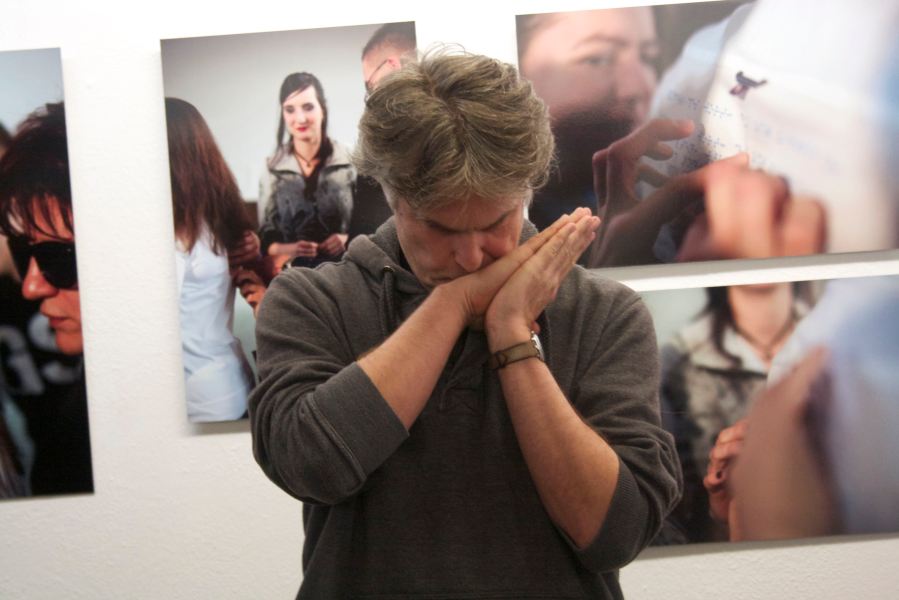 Der grauhaarige Mann scheint nachzudenken, das Gesicht auf die zusammengelegten Hände gelegt