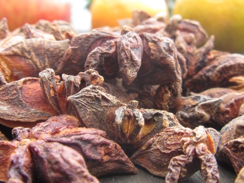 Orangen, Apfel und Anis auf Holztisch