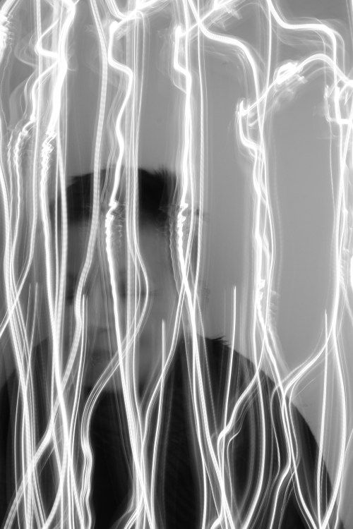 Eine von vertikalen Lichtstreifen verdeckte Frau