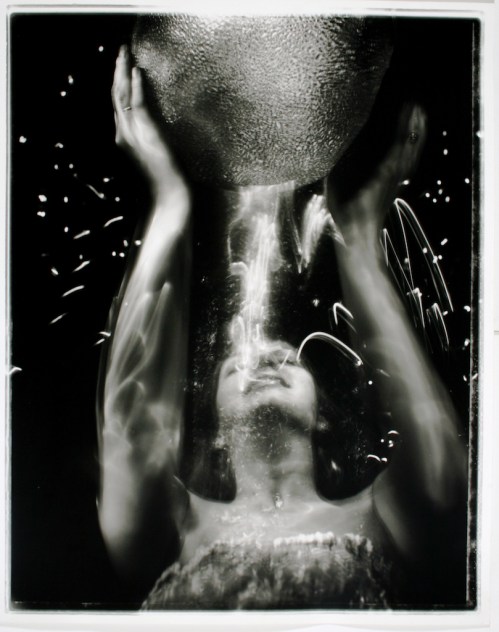 Eine Junge Frau hebt eine Schale über ihren Kopf