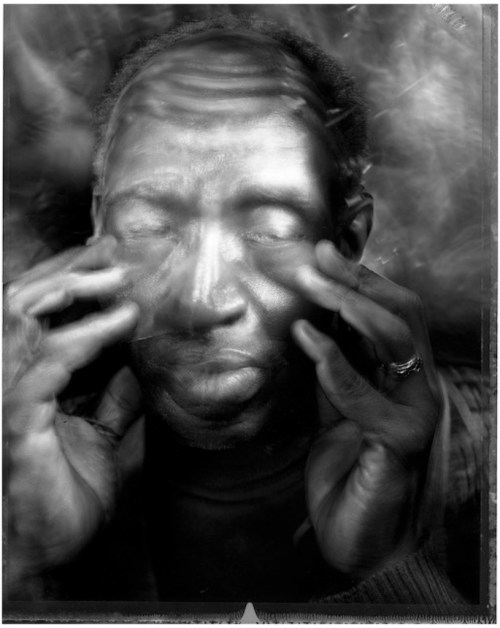 Ein Mann mit geschlossenen Augen betastet sein Gesicht